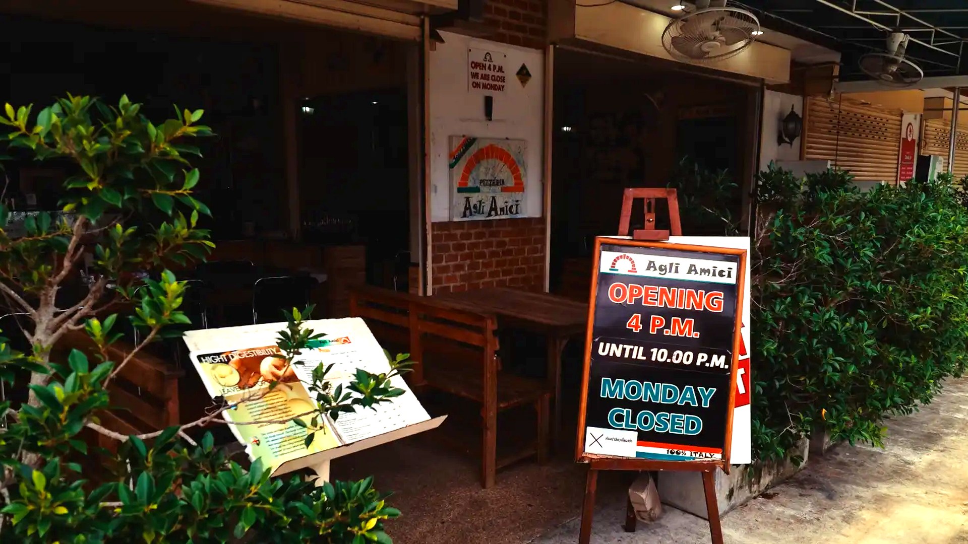 Entrance of Agli Amici Phuket with opening hours board, cozy hidden gem Italian restaurant