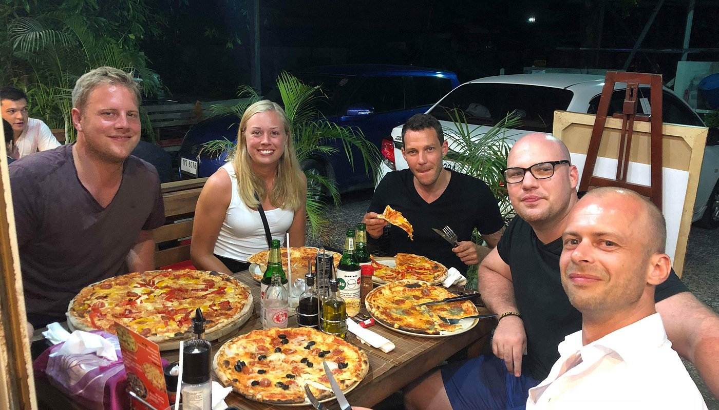 Friends and family enjoying authentic Italian pizza at Agli Amici Phuket, cozy hidden gem in Chalong